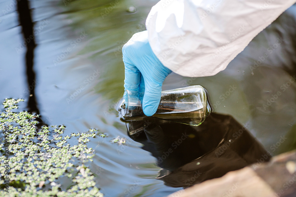 a scientist filling up a vial of water for testing