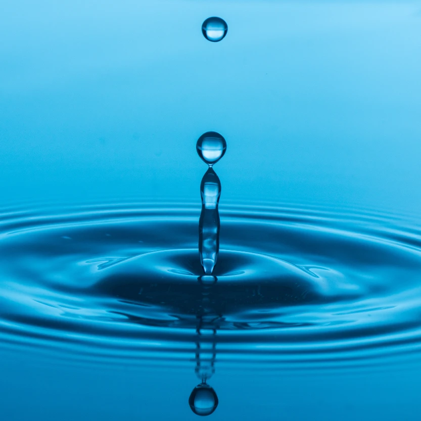 a water droplet dropping into some liquid and making a splash