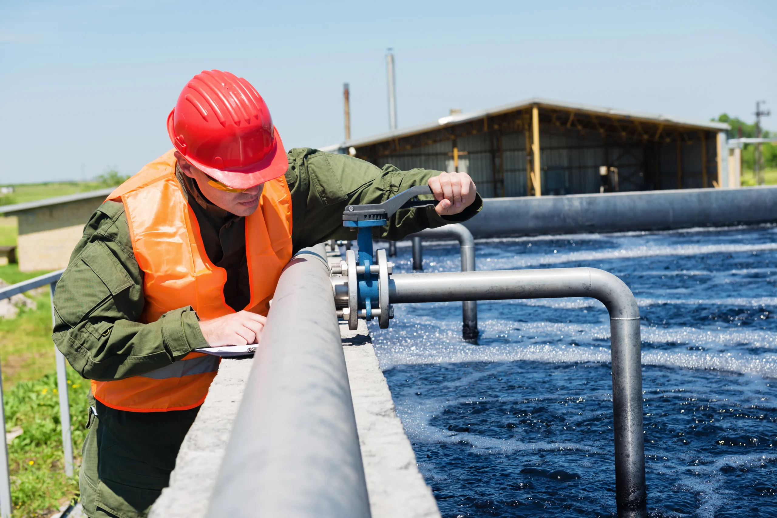 a worker fixing a pipe that is treating water