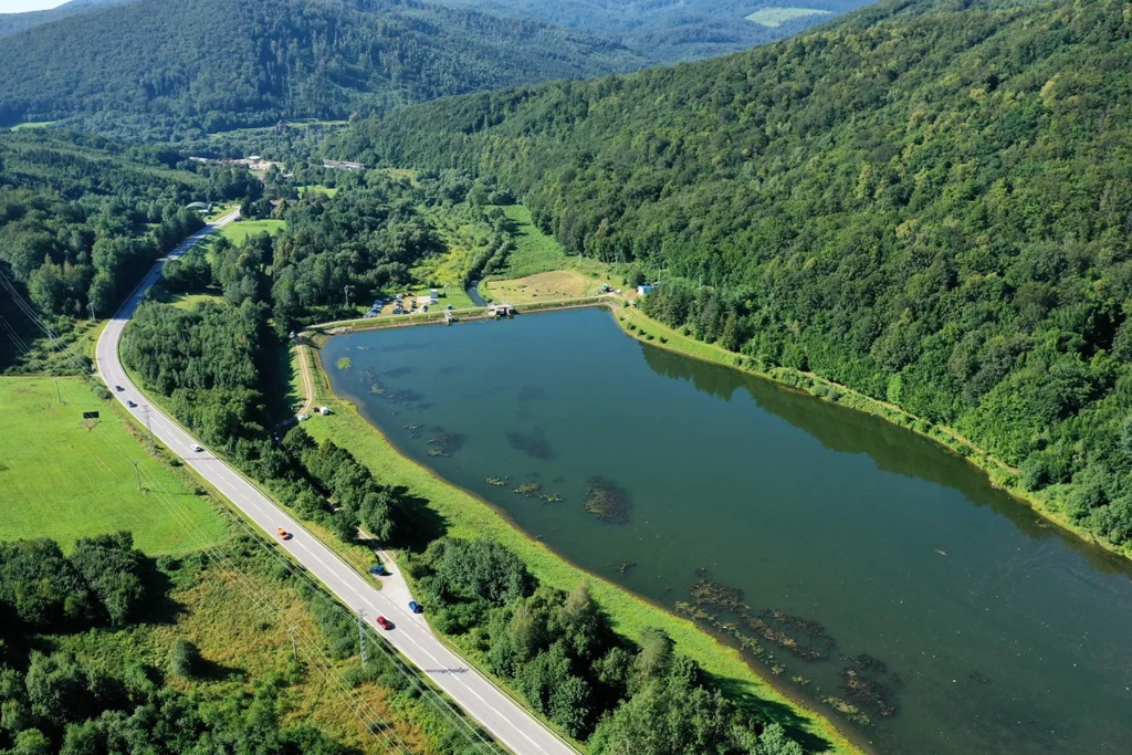 an above view of a river with trees all around it