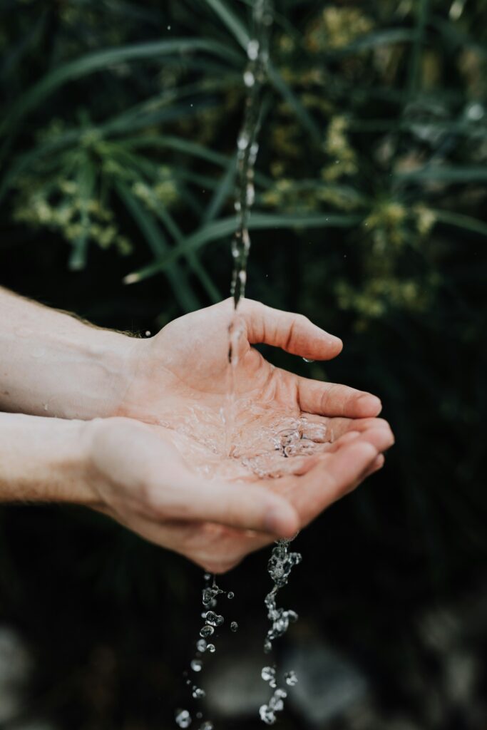 Person running hands under water