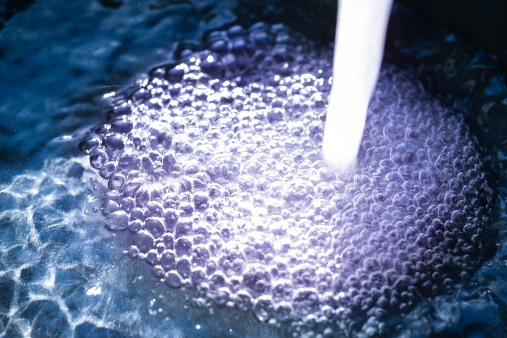 Close-up of aerated water with bubbles forming around a flowing water stream.