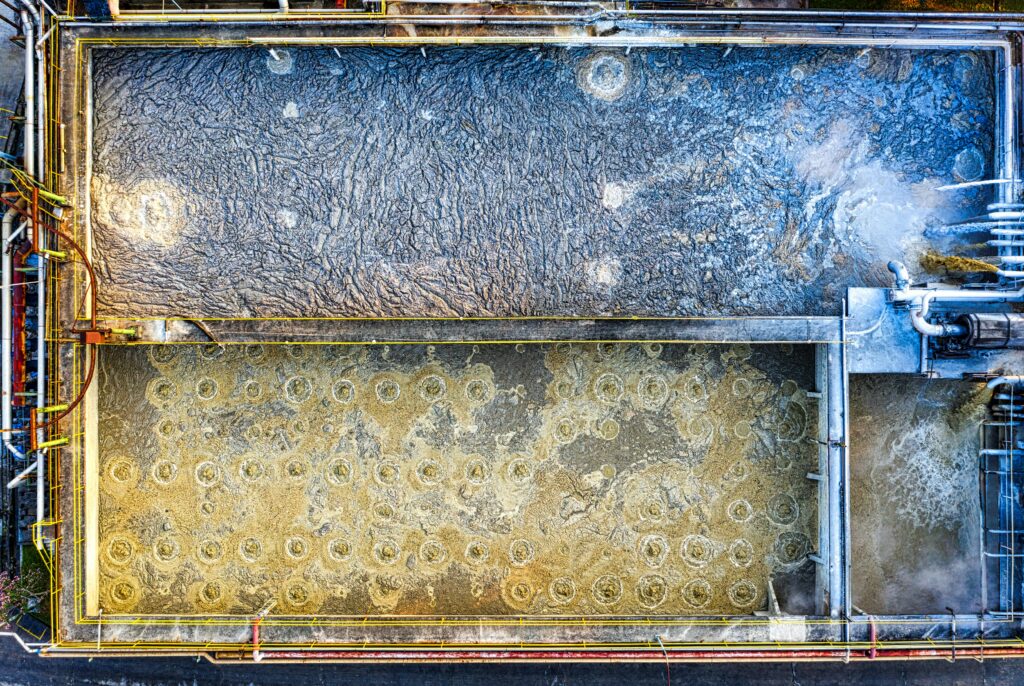 Aerial view of an industrial wastewater treatment facility with aeration tanks and processing equipment.
