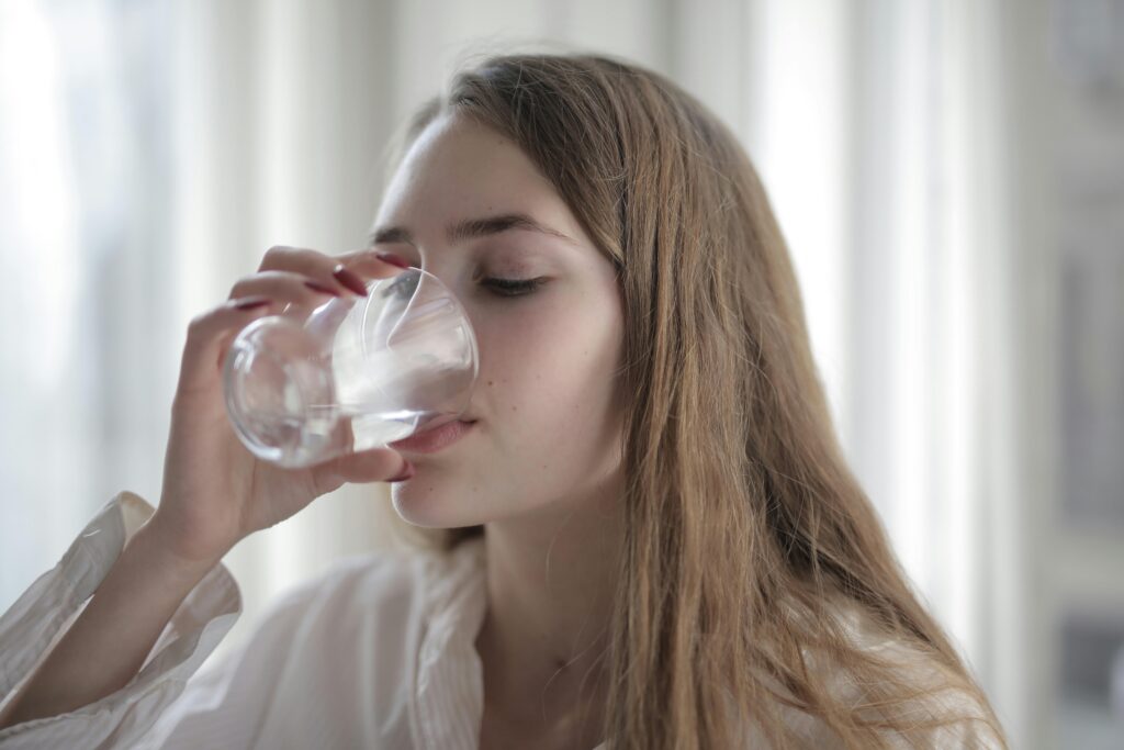 Woman drinking water from a glass cup